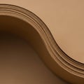 A close-up image of a stack of brown paper sheets with a distinctive wavy curve. The Royalty Free Stock Photo