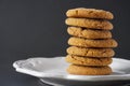 Close-up image of a stack of ginger Christmas cookies on a white plate with a black background