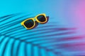 Close-up image of sunglasses on turquoise blue background with palm tree shadow Royalty Free Stock Photo