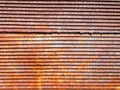 Image of surface of a wall of corrugated roof. Rusty metal