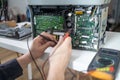 Close-up image of technician man hand measuring electrical voltage of computer mainboard by using digital multimeter. Royalty Free Stock Photo