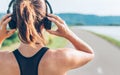 Close up image of teenager adjusting wireless headphones before starting jogging and listening to music