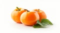 Close-up image of three orange persimmons placed on a white background, accompanied by bright green leaves Royalty Free Stock Photo