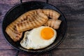 Close-up image of a traditional breakfast dish of crisp bacon strips, fried eggs Royalty Free Stock Photo