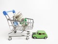 Close up image trolley with bank notes and car miniature.