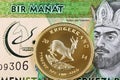 A Turkmenistani 1 manat bank note with a South African krugerrand Royalty Free Stock Photo