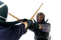 Close-up image of two men, professional kendo athletes in uniform training bamboo shinai sword against white studio Royalty Free Stock Photo