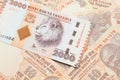 An orange Tanzanian shilling note with Indian ten rupee bank notes