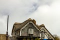 Close up image of a vintage house with thatched roofs.