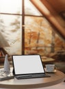 A close-up image of a white-screen digital tablet mockup on a wooden table in a cozy autumn cabin Royalty Free Stock Photo