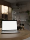 Close-up image of a white-screen laptop computer mockup on a wooden table in a room Royalty Free Stock Photo