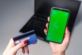 Close up image of woman hands using smartphone blank green screen mockup and holding credit card Royalty Free Stock Photo