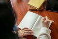 A woman holding a pencil, writing in a notebook, doing homework, keeping her diary Royalty Free Stock Photo