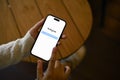 Close-up image of a woman login on her Instagram on her phone while relaxing in a cafe