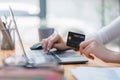 Close-up image of a woman making an online purchase on a computer using a mockup credit card. Selective focus Royalty Free Stock Photo