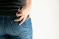 A woman keeps a short wallet in the back pocket of jeans on a white background with copy space