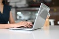 A close-up image of a woman is using a computer laptop at the white desk. Royalty Free Stock Photo