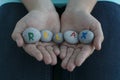 close up image of young female hands hold gray round stones with letters on them and inscription relax.