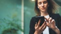 Close-up image of young hipster girl using modern smartphone device near office, female hands typing text message via cellphone Royalty Free Stock Photo