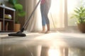 A close-up image of a young maid using a vacuum cleaner to clean a carpet at home. Royalty Free Stock Photo