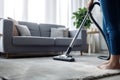 A close-up image of a young maid using a vacuum cleaner to clean a carpet at home. Royalty Free Stock Photo