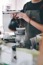 Close up image Young male barista pouring boiling water from kettle for filter coffee Royalty Free Stock Photo