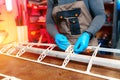 Close-up image of young male engineer or technician working on drone details in lab. Plane wing.