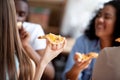 Close up image of young woman holding slice of pizza.