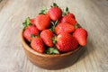 Close up image of yummy delicious big red strawberry lie in round wooden plate