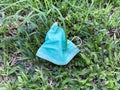 Close up of improperly discarded used face mask thrown on to grass patch