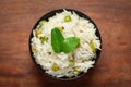 Close-up of Indian Basmati steamed Rice or matar Pea pulao or Pulav garnished with fresh green mint leaf in a black bowl Royalty Free Stock Photo