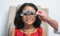 Close up, Indian child girl doing examine eyesight with trial frame and lens with ophthalmologist or optometrist for eyes test