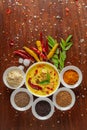 Close-up of Indian kadi or kadhi pakora with it basic ingredients. Garnished with green curry-patta leaves and red chili flacks.