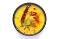 Close-up of Indian traditional kadhi or kadi pakora yogurt and gram flour and turmeric served hot in a black bowl.