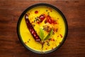 Close-up of Indian traditional kadhi or kadi pakora yogurt and gram flour and turmeric served hot in a bowl.