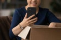 Close up Indian woman using smartphone and unpacking parcel Royalty Free Stock Photo