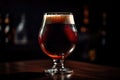 close-up of individual glass of draught beer with foamy head and rich color