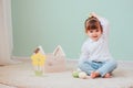 Indoor portrait of cute happy baby girl playing with easter decorations