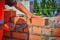 Close up of industrial bricklayer installing bricks on construction site. worker with bricks Royalty Free Stock Photo
