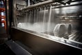 close-up of industrial dishwasher, with cascade of water and steam