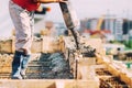 Close up of industrial worker pouring cement or concrete with automatic pump tube Royalty Free Stock Photo