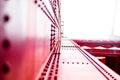 Close-Up of Industrial Red Metal Structure Highlighting Rivets and Architectural Design Elements in a Modern Engineering and Royalty Free Stock Photo