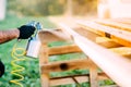 Industrial worker using paint gun or spray gun for applying paint on brown timber wood Royalty Free Stock Photo