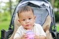 Close-up infant baby boy sitting on stroller and drinking water from Baby sippy cup with straw Royalty Free Stock Photo