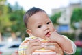 Close-up Infant baby boy is sucking finger with Asian mother carrying Royalty Free Stock Photo