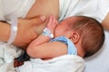 Close-up infant baby feeding from mother breastfeeding her newborn child on the hospital bed Royalty Free Stock Photo