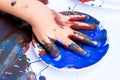 Close up of infant hand soaked in blue paint. Royalty Free Stock Photo