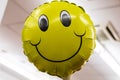 Close up of inflated yellow smiling face balloon