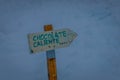 Close up of informative sign of hot chocolate written over a wooden structure and pointing to one direction in the