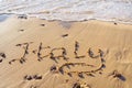 Close-up of inscription word Italy written on sand of beach seashore coastline after tide near sea waves on sunny day. Royalty Free Stock Photo